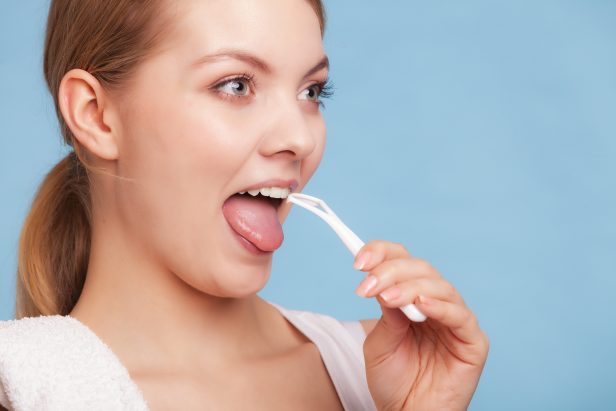 Girl cleaning tongue. Dental care oral hygiene.
